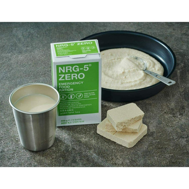 NRG-5 Zero emergency vegan survival food pack with powdered ration, prepared meal, and metal cup on gray surface