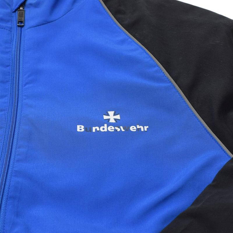 Close-up of blue and black Bundeswehr sports jacket with zip front and reflective piping detail.