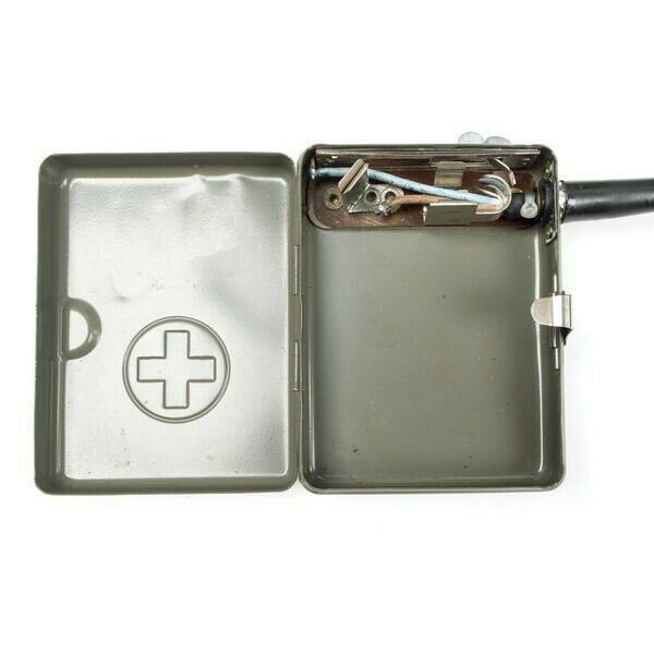 Open vintage Swiss army headlamp metal case with visible internal wiring and Swiss cross emblem on lid