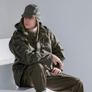 Man wearing an original Austrian army M65 olive drab combat jacket and matching military hat sitting indoors.