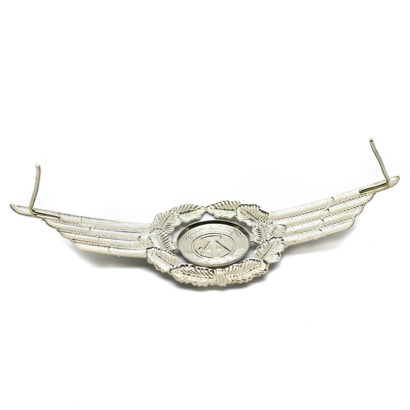 Original East German NVA officer military cap cockade pin badge with detailed wreath and winged design in silver tone