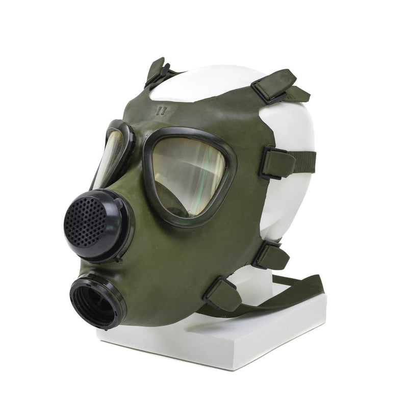 Vintage Romanian M74 full face olive green gas mask with adjustable straps and dual circular eyepieces displayed on mannequin head